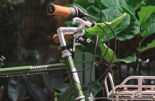 The handlebar of a green bicycle